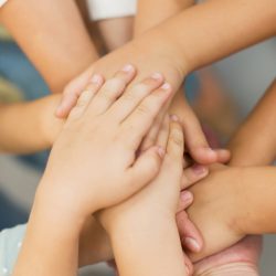 teacher-putting-her-hands-together-with-her-students-close-up teacher-putting-her-hands-together-with-her-students-close-up
